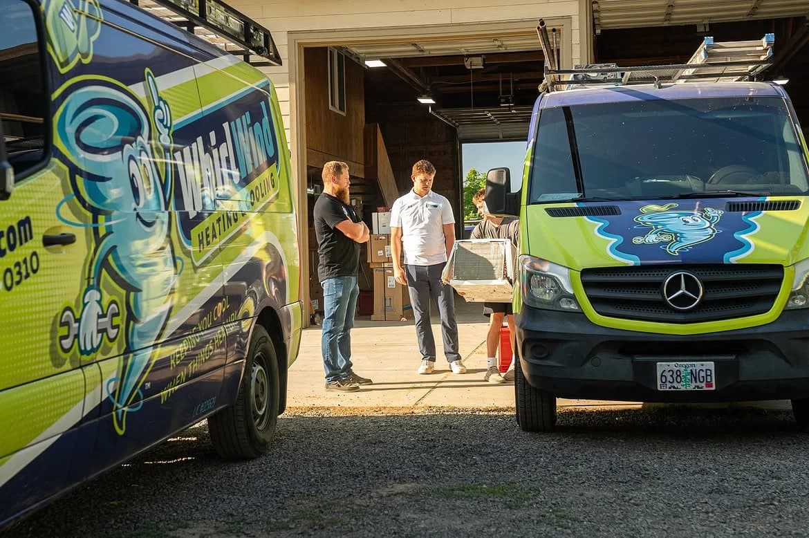 Whirlwind crew members standing between branded service vans