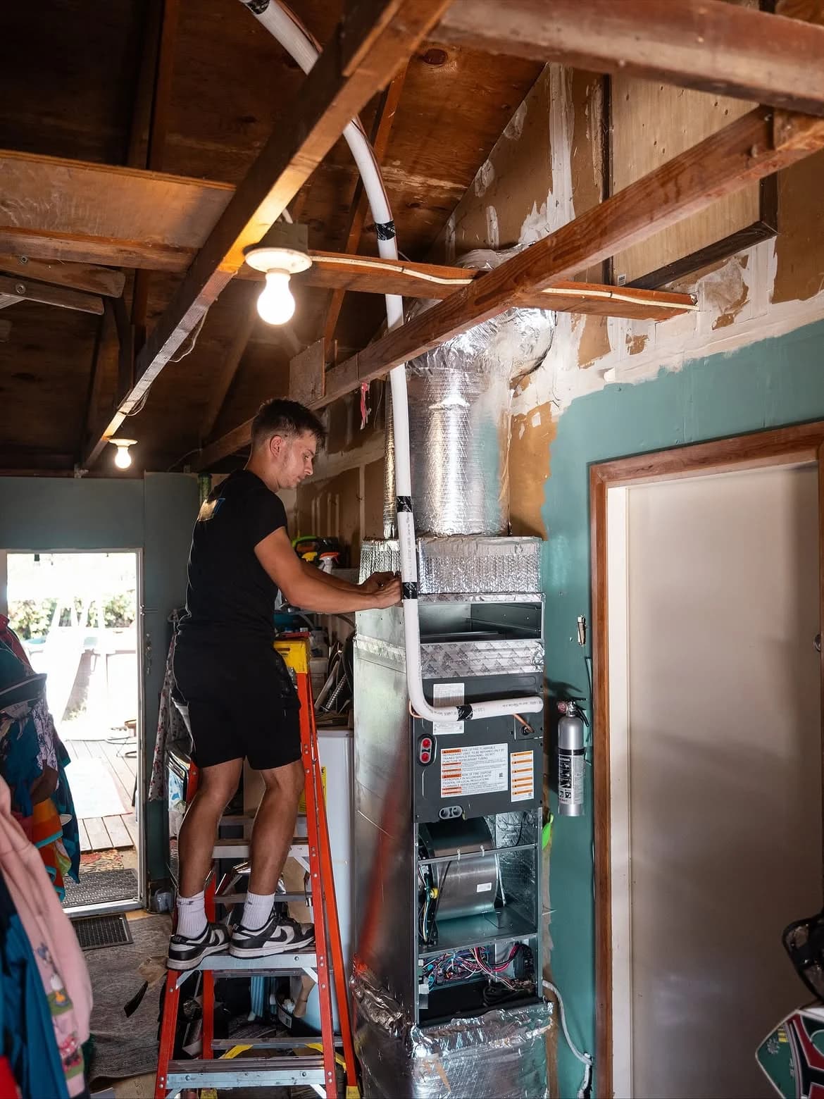 Whirlwind technician working on a furnace and the connected air ducts