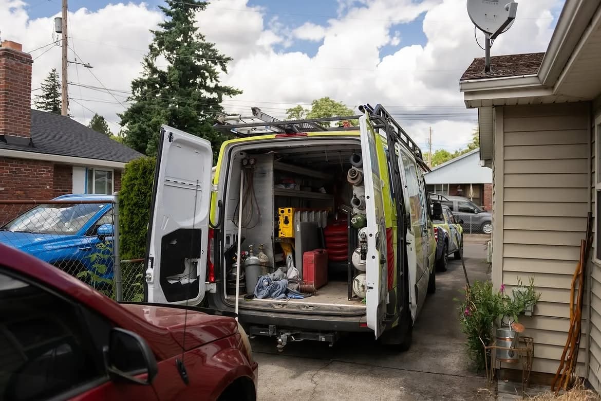 An open Whirlwind service van stocked with tools and materials at a home